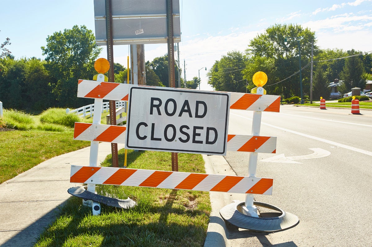 A road closed sign on the side of a road