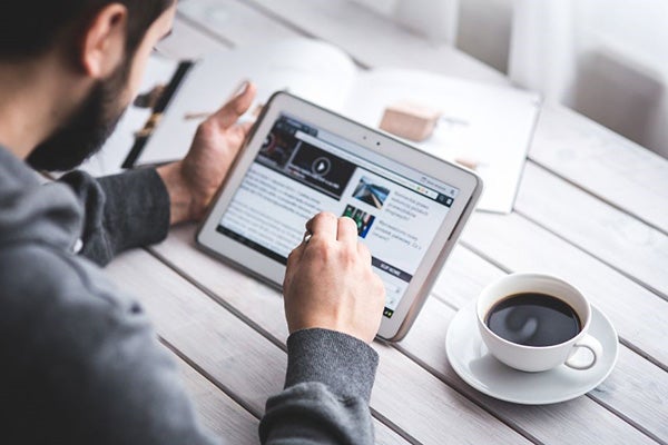 a man using a tablet to look at the news