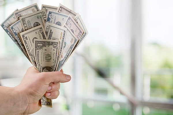 Close up of a hand holding a fistful of cash