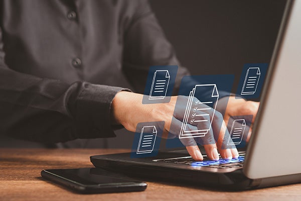 Businessman working at a laptop and digital documents with checkbox lists on virtual screen. Online documentation database and digital file storage concept.